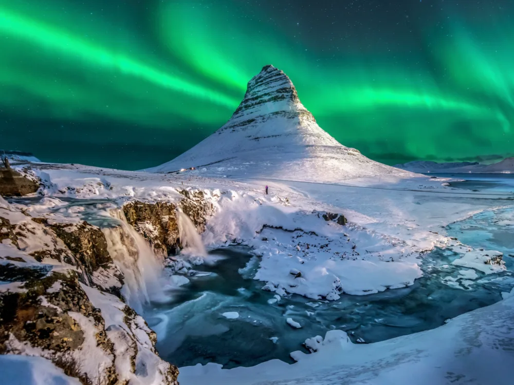 Cool view of the northern lights over Mount Kirkjufell for a piece on the best hotels in Iceland