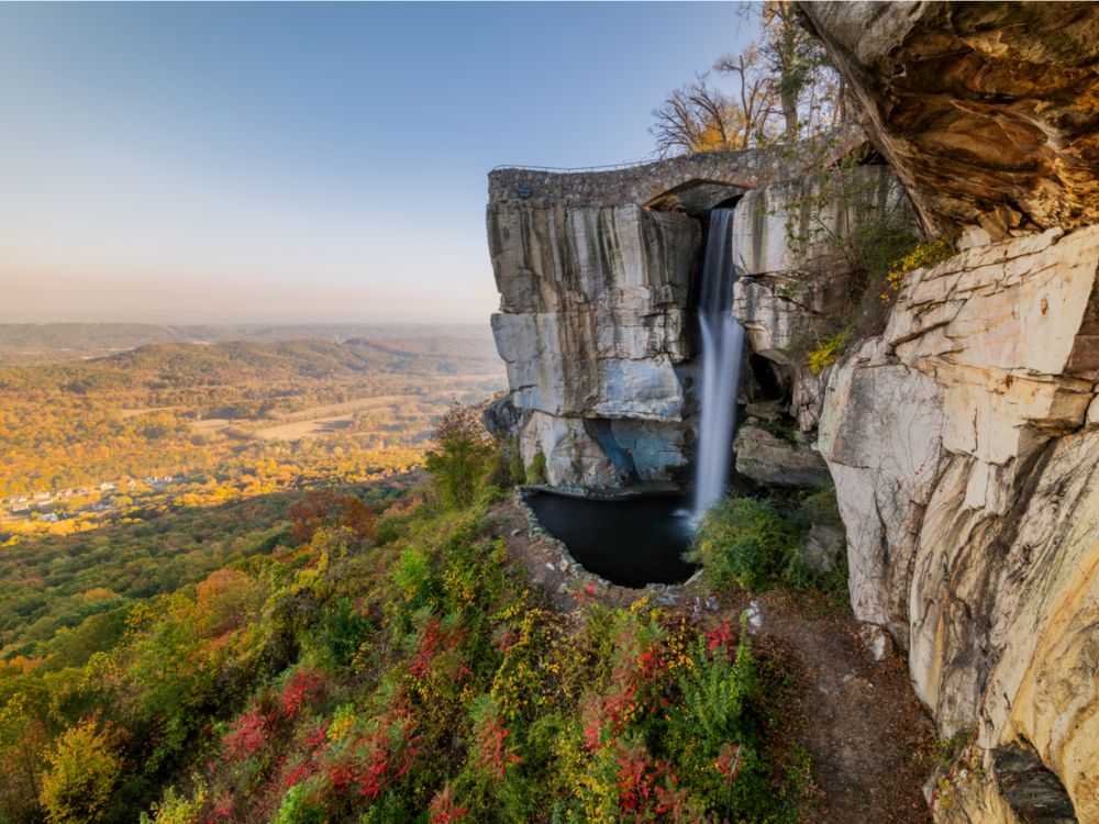 A view on man-made High Falls and Lovers Leap standing above a green natural landscape at Rock City, a piece on the best tourist attractions in Georgia