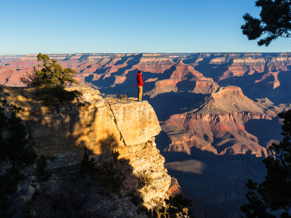 Man on a rock ledge pictured during the least busy time to visit the Grand Canyon