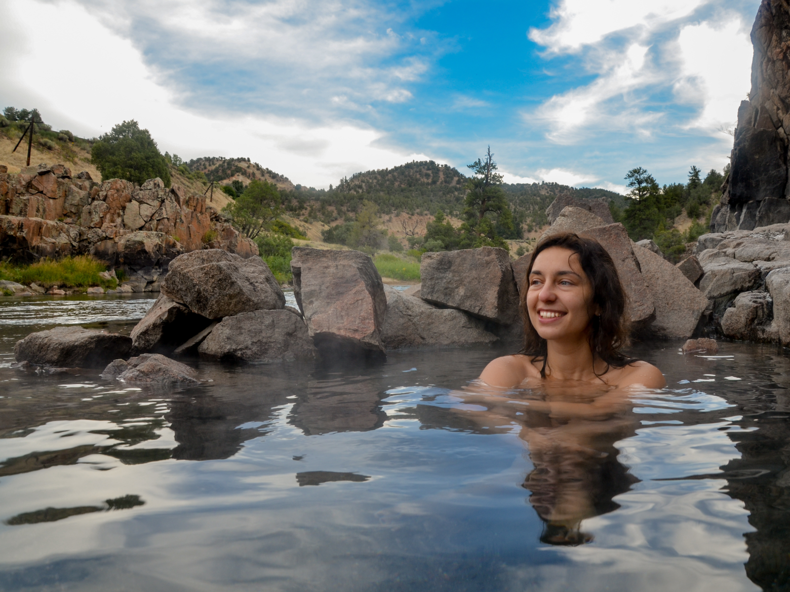 Female sitting in a primitive hot springs in Colorado
