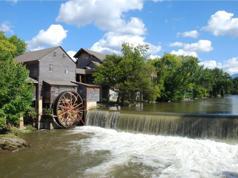 The Old Mill by the tranquil river at Pigeon Forge, one of the best places to visit in Tennessee, showing rows of old houses