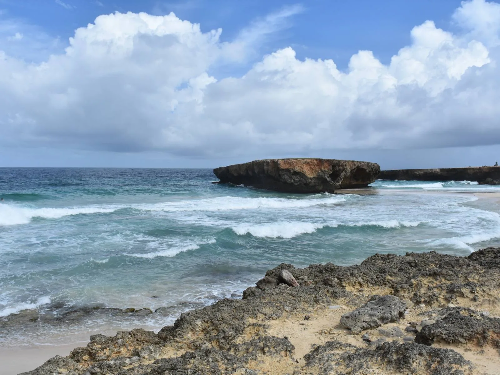 A large Moro Rock formation and a rocky coast smashed by strong waves offshore of Boca Keto, one of the best beaches in Aruba