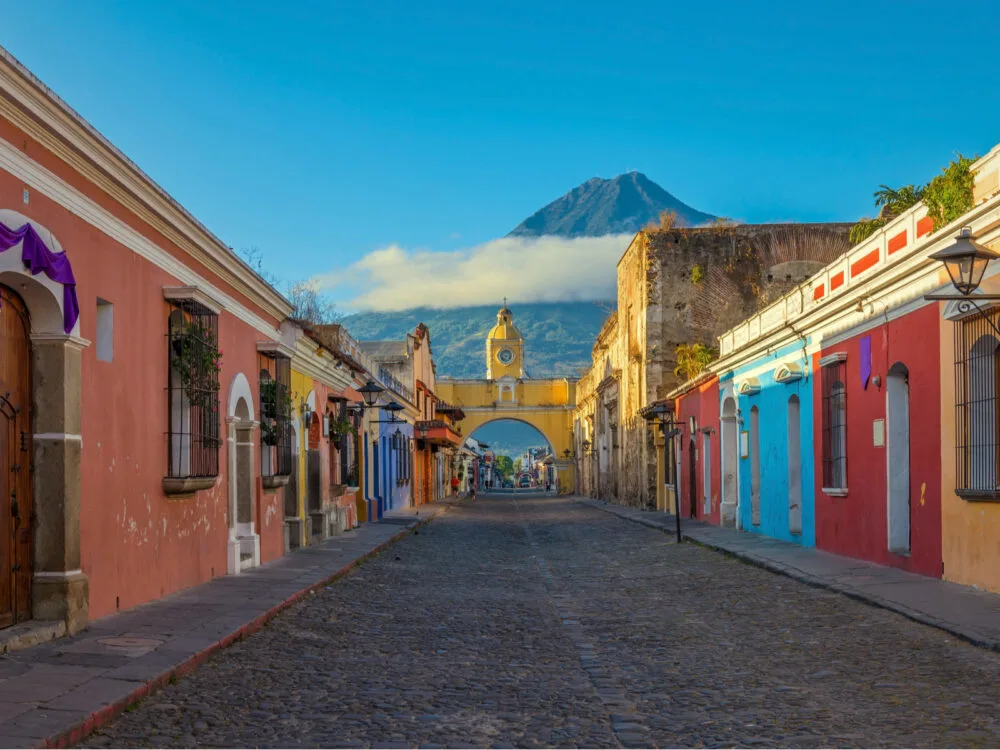 Bold view of the main street in Antigua, one of the best places to visit in the Caribbean, with a volcano in the background