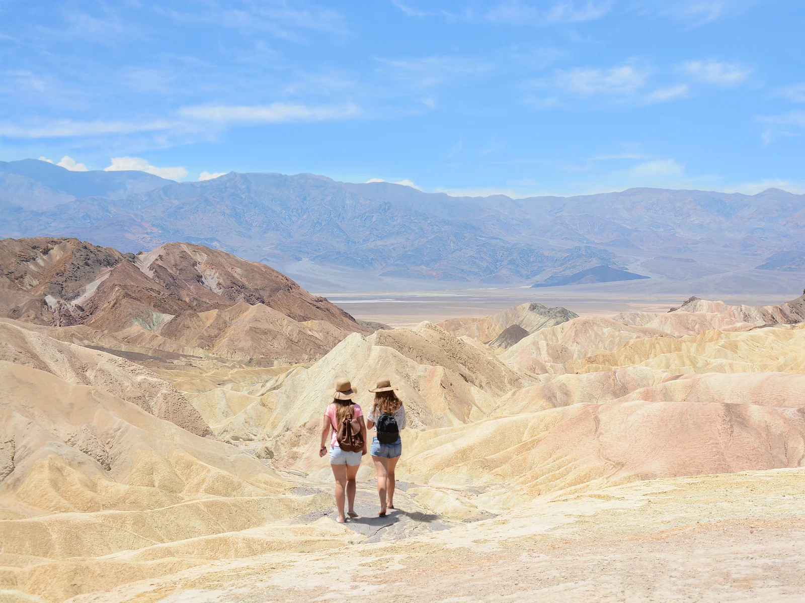 Two friend in jean shorts hiking during the least busy time to visit Death Valley park