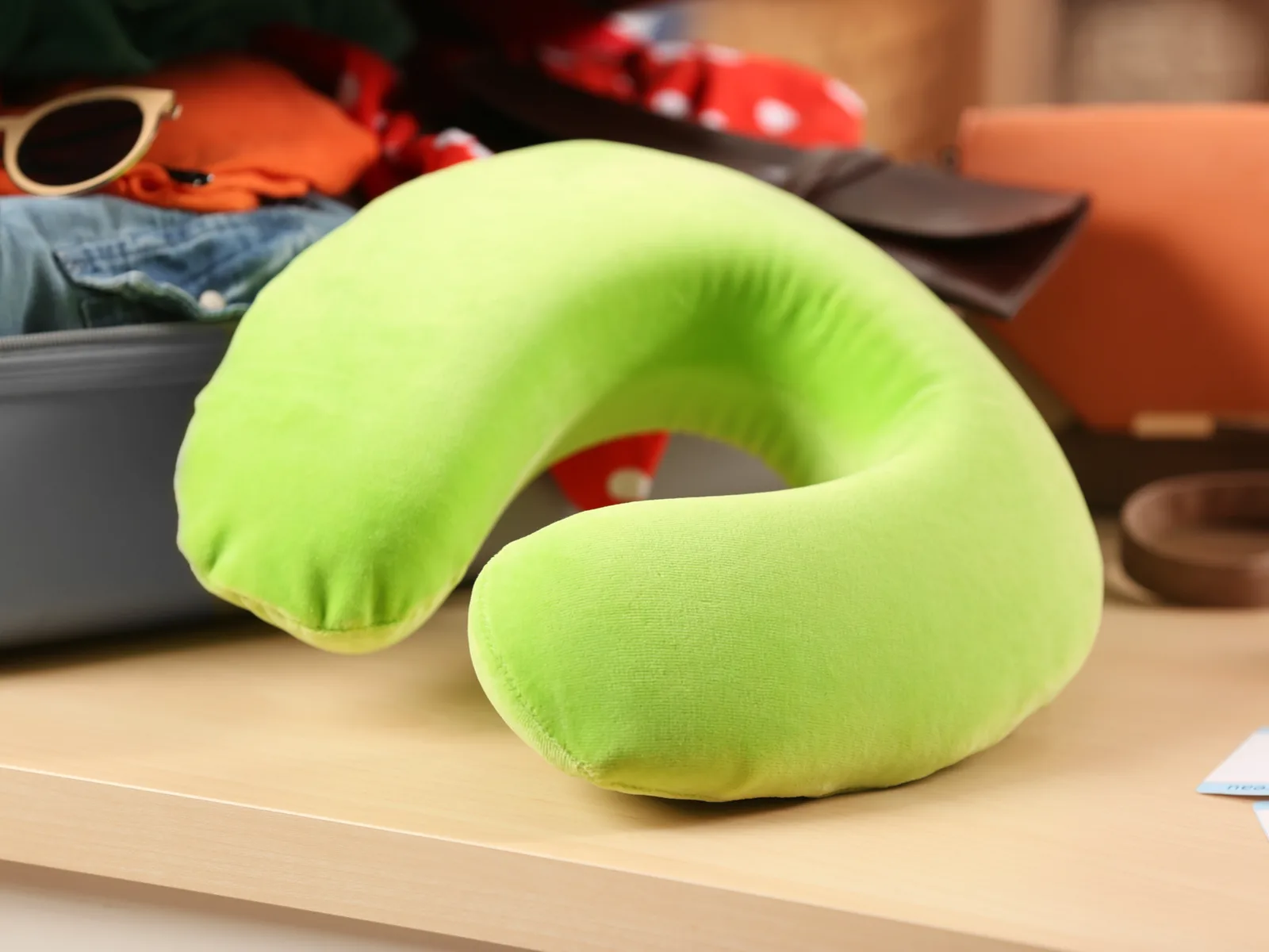 One of the best travel pillow in lime green sitting on a light tan shelf