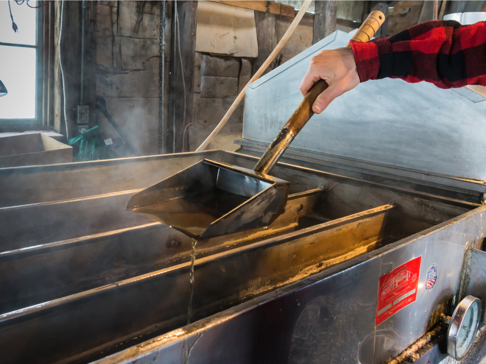 Steam rising off a boiler in one of the best places to visit in Vermont, a maple syrup tour