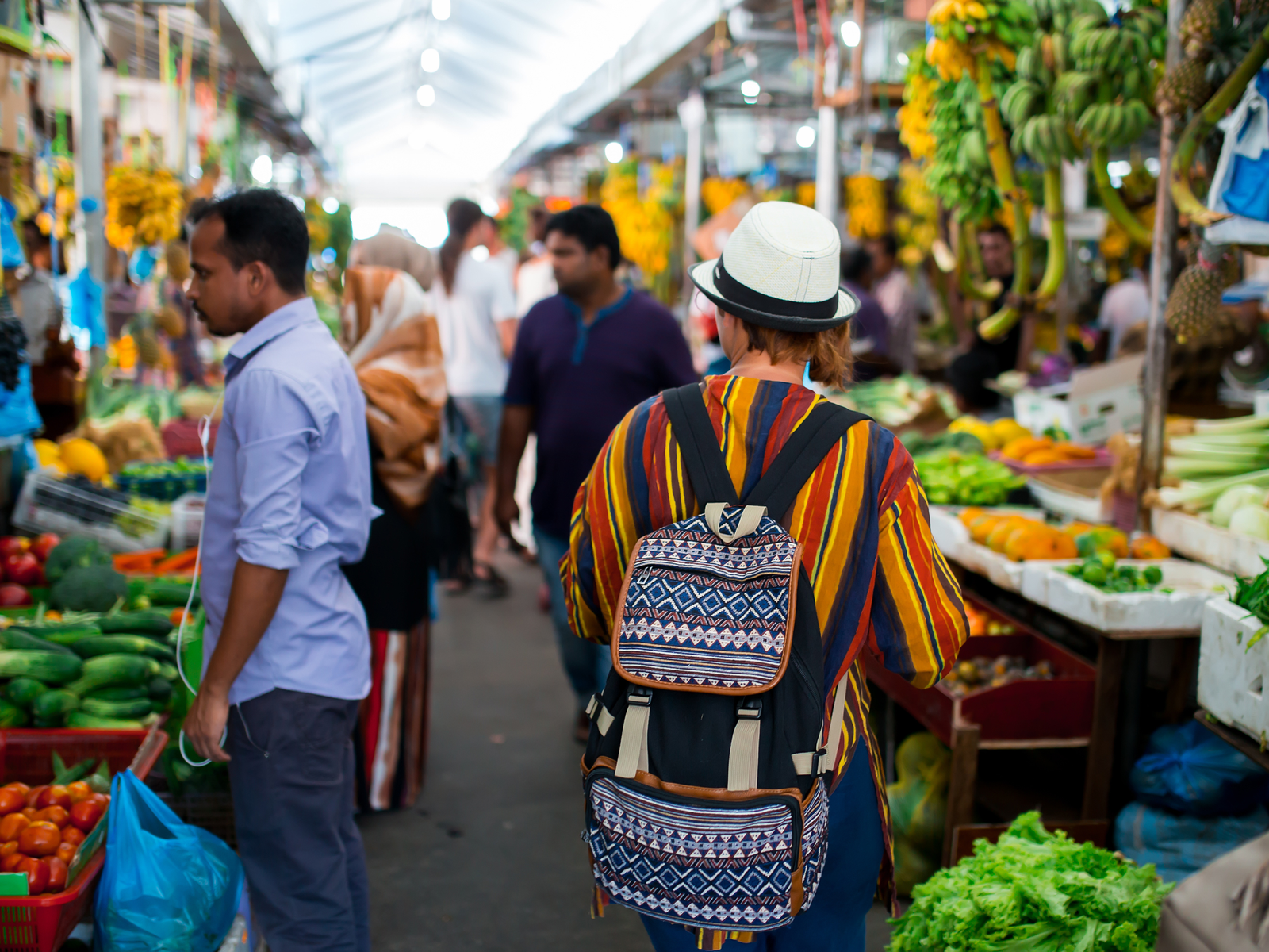 Guy walking through a market during the best time to visit Maldives