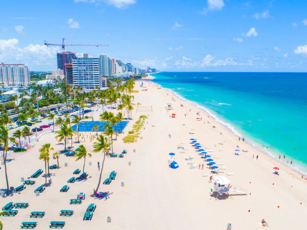 Long stretch of white sand beach on a sunny day in one of the best places to visit in Florida, Fort Lauderdale