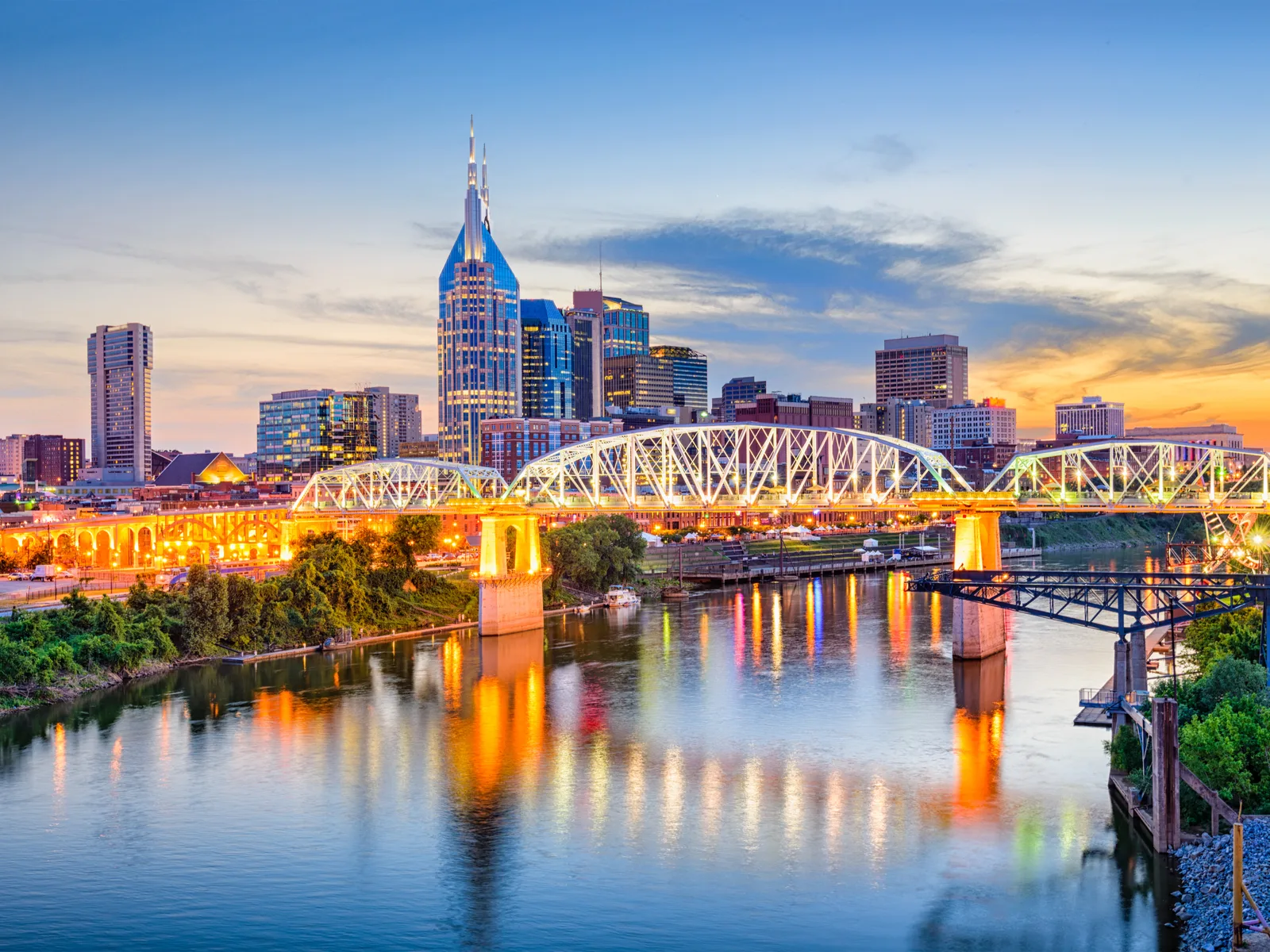 Image of Nashville, Tennessee at dusk with an aerial shot of the skyline over the river