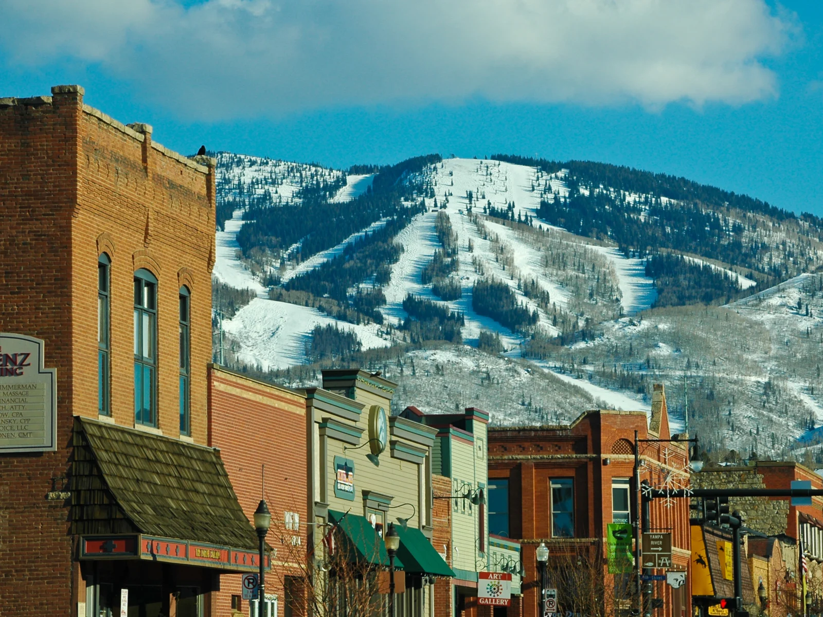  Downtown Steamboat Springs photographed with various store buildings and worm's-eye view of a skiing trial in Steamboat Ski Resort, as a piece on one of the best ski resorts near Denver