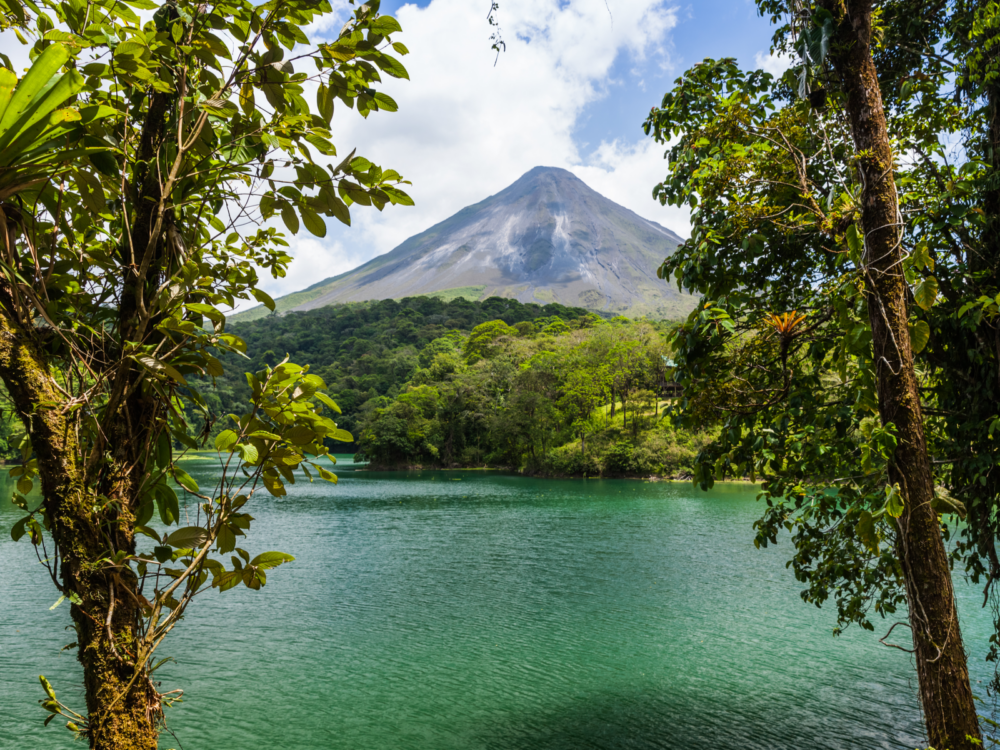 Cool view of Volcano Arenal through the trees, one of the best places to visit in Costa Rica