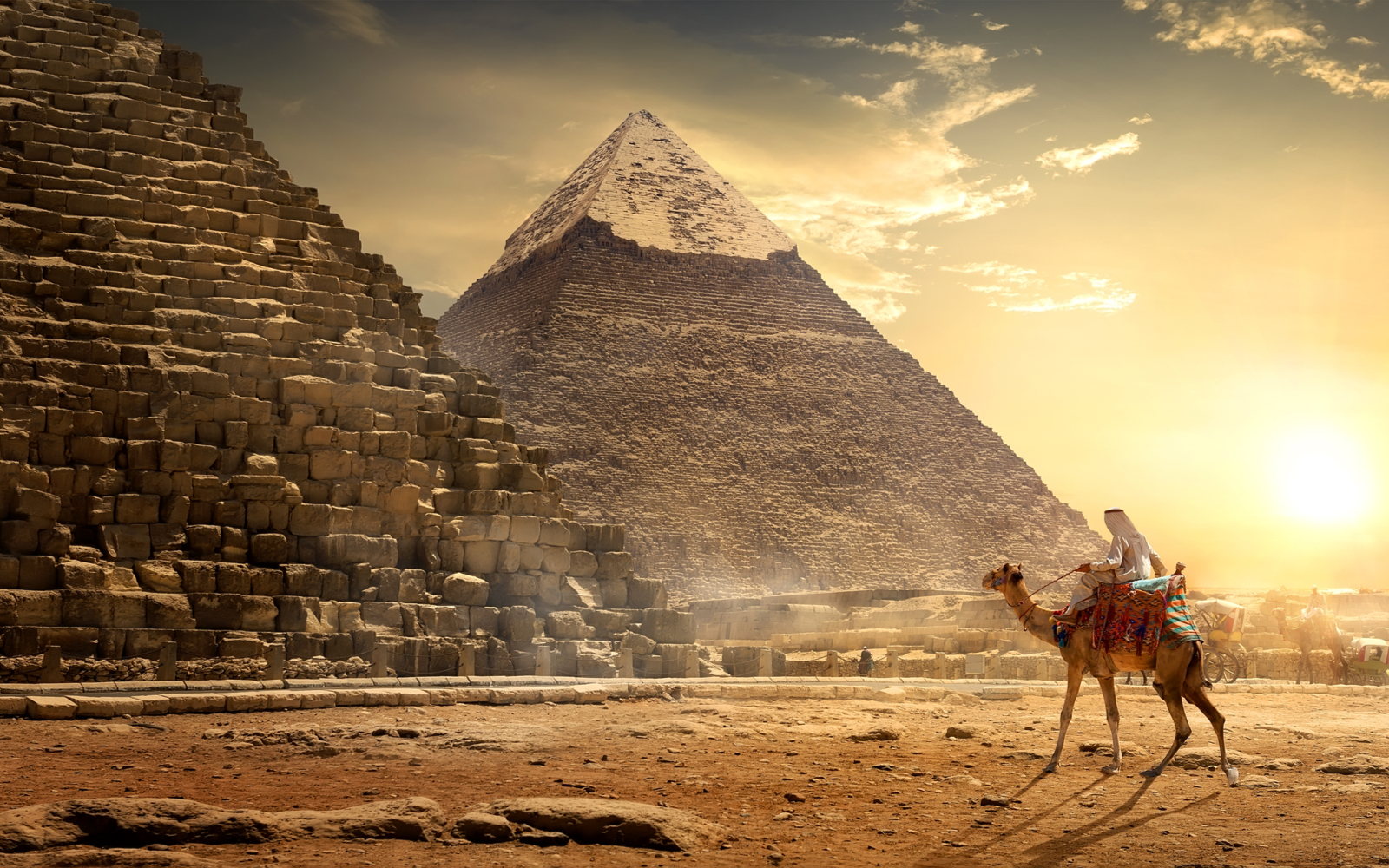 Man on a camel at the base of the great pyramids during the best time to visit Egypt