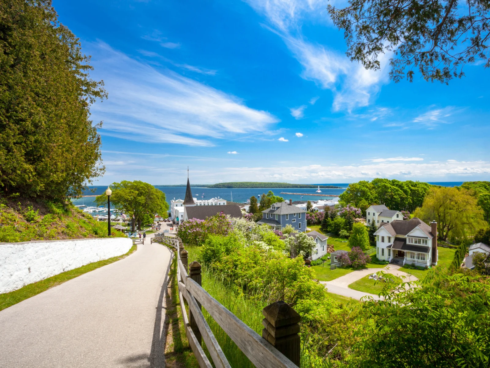 View of Mackinac Island from the top of a walking trail with lots of greenery and blue sky