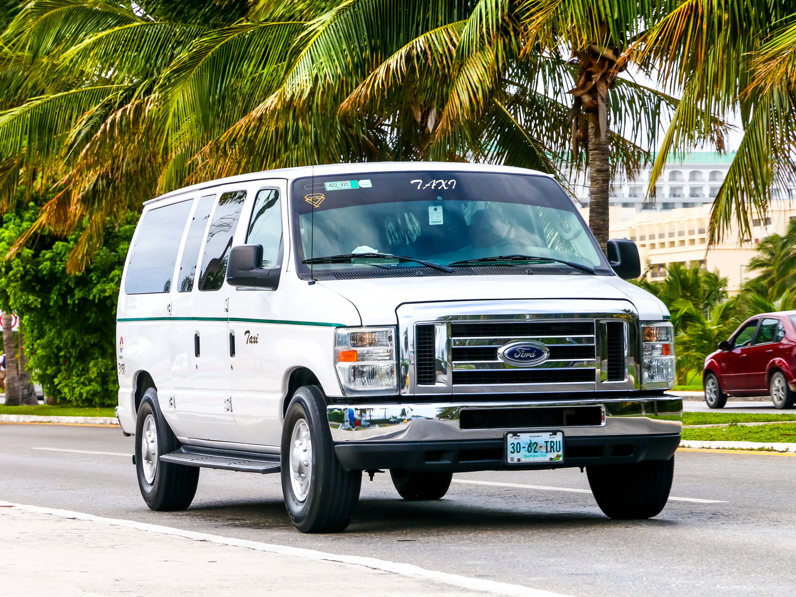 A white ford econoline taxi going to the best all-inclusive resorts in Cancun