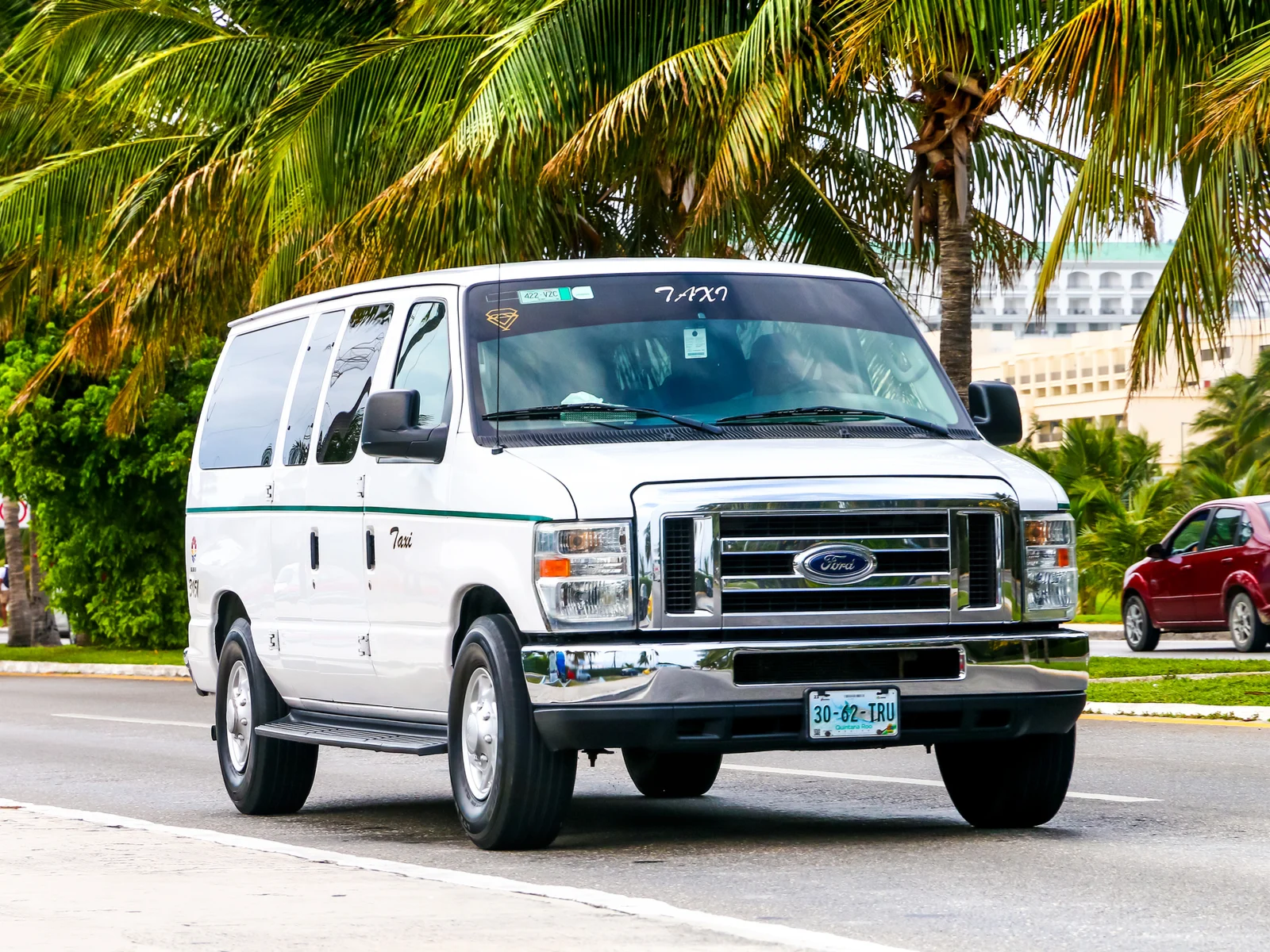 A white ford econoline taxi going to the best all-inclusive resorts in Cancun