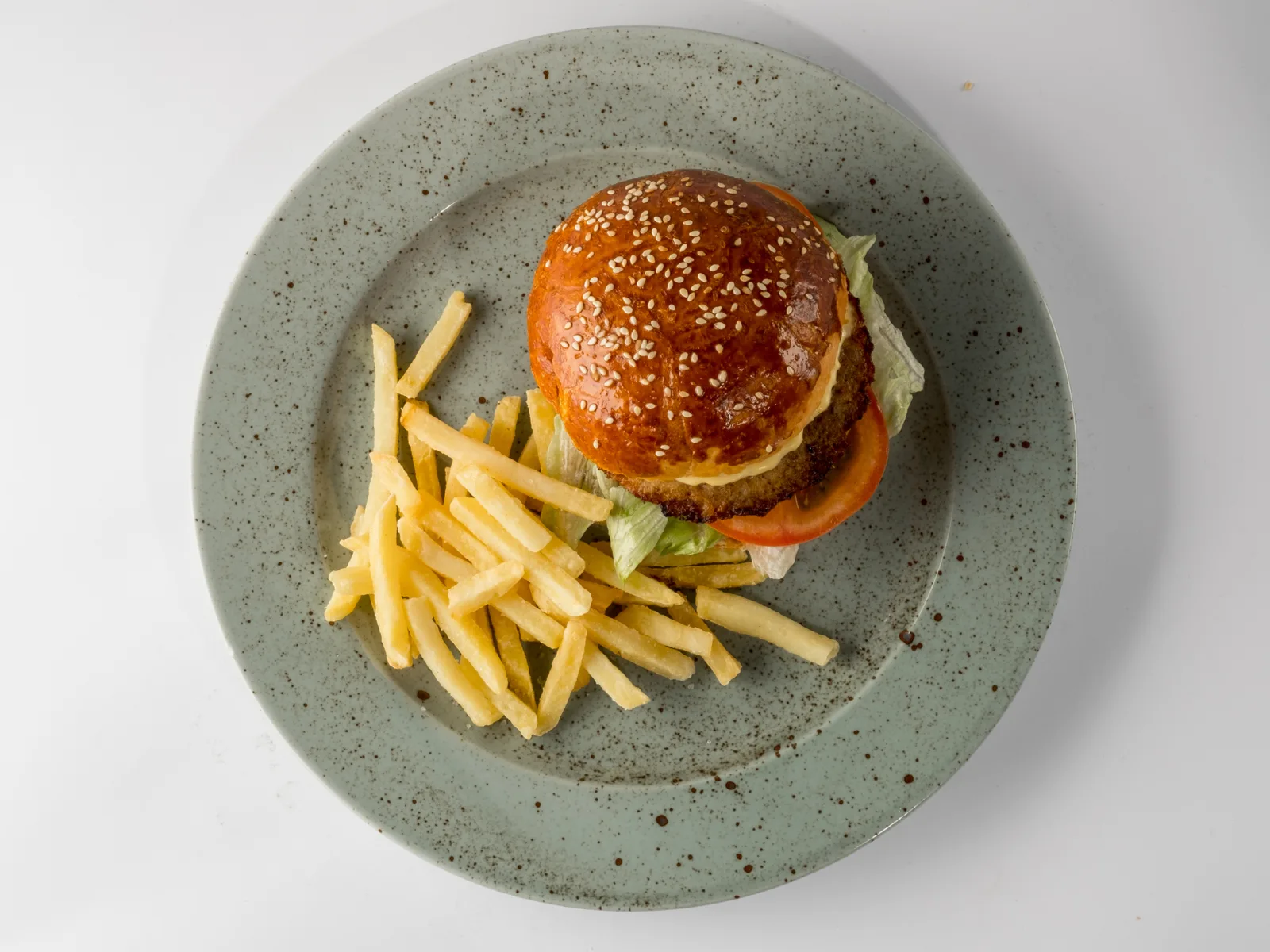 Burger and fries combination served on a grey spotted plate at one of the best restaurants in Iceland, Bautinn