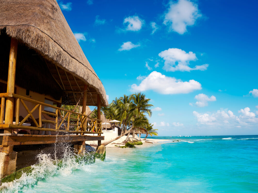 Cabana and palapa pictured with blue water and blue sky during the best time to visit Cancun