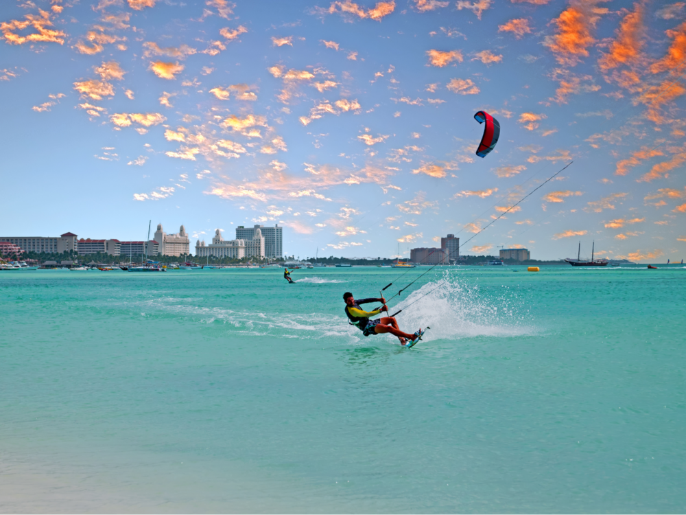 Guy kiteboarding on a beach, one of our favorite things to do in Aruba