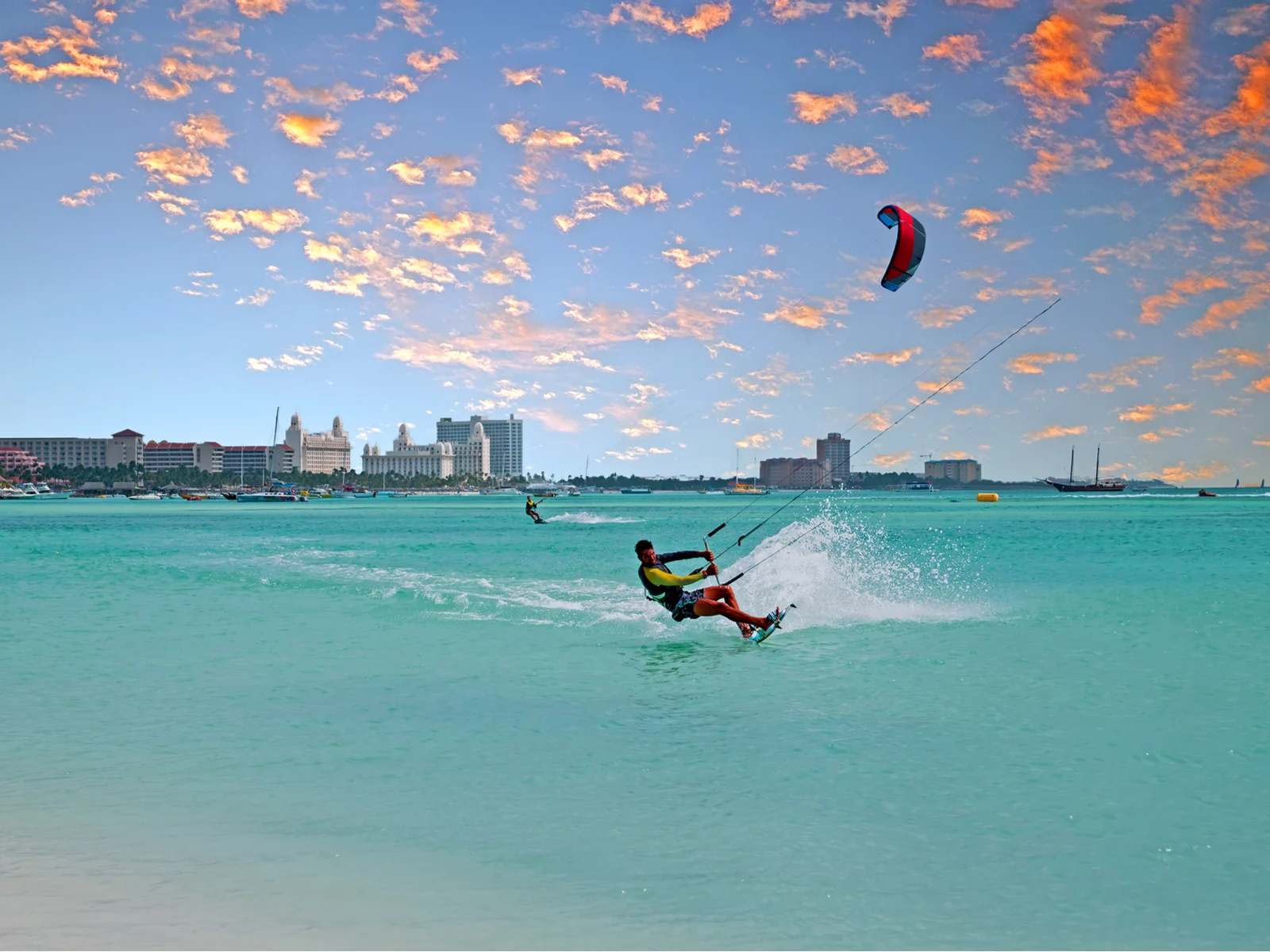Guy kiteboarding on a beach, one of our favorite things to do in Aruba