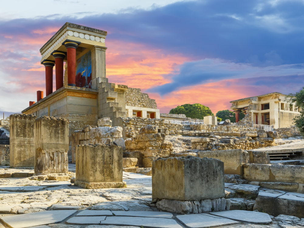 Sunset over the ruins of Knossos Palace at Crete, named as one of the best places to visit in Greece, with large old broken columns