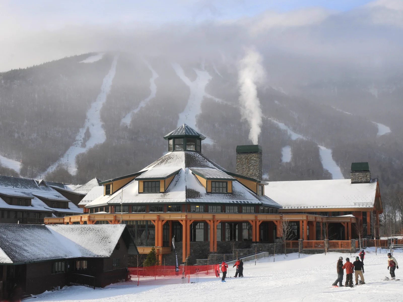 People skiing at the base of a mountain in Stowe, Vermont