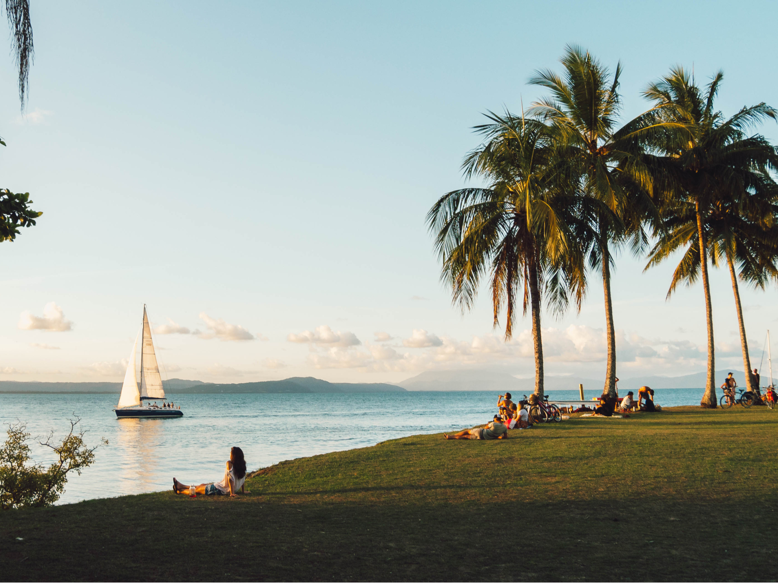 Gorgeous beach in Port Douglas pictured during the best time to visit with a sailboat in the background