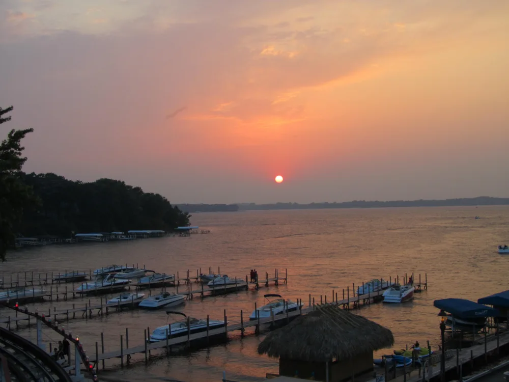 A pick for what to see in Iowa, sweet sunset on Lake Okoboji with several boats docked on boardwalks