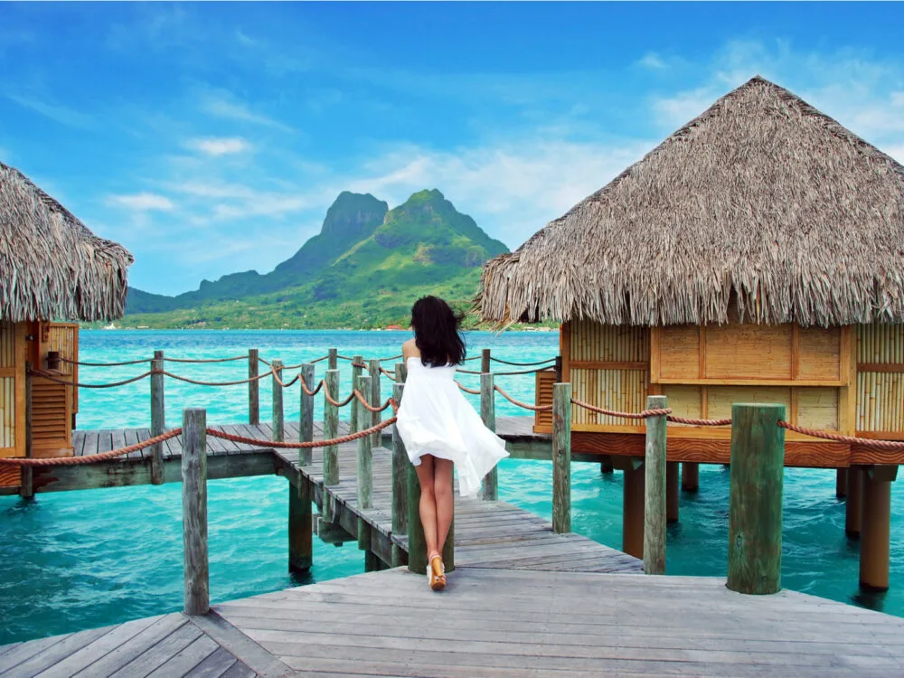 Young lady standing on a dock in Bora Bora during the best time to visit