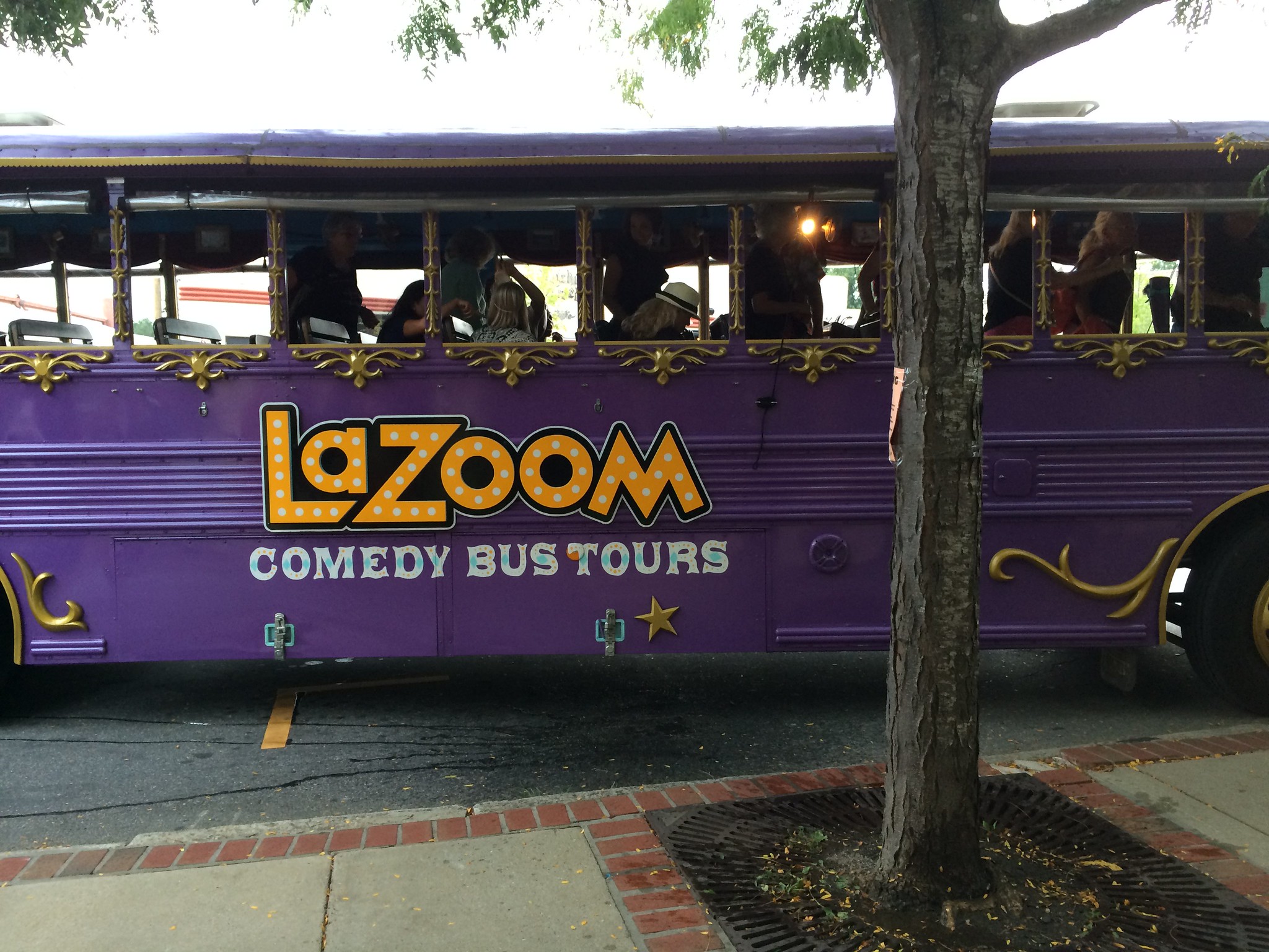 A purple touring Lazoom Comedy Bus with open windows, one of the best things to do in Asheville, NC