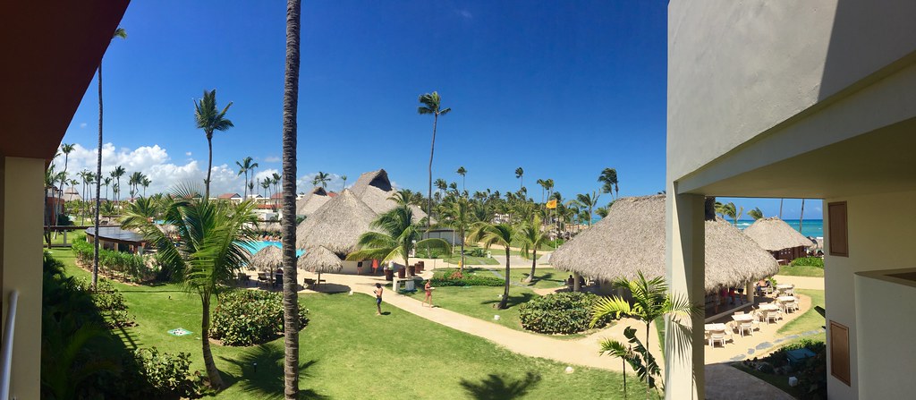 Panoramic photo on the scenic interior of Breathless Punta Cana Resort and Spa, a piece on the best all-inclusive resorts in Punta Cana, with native huts and palm trees