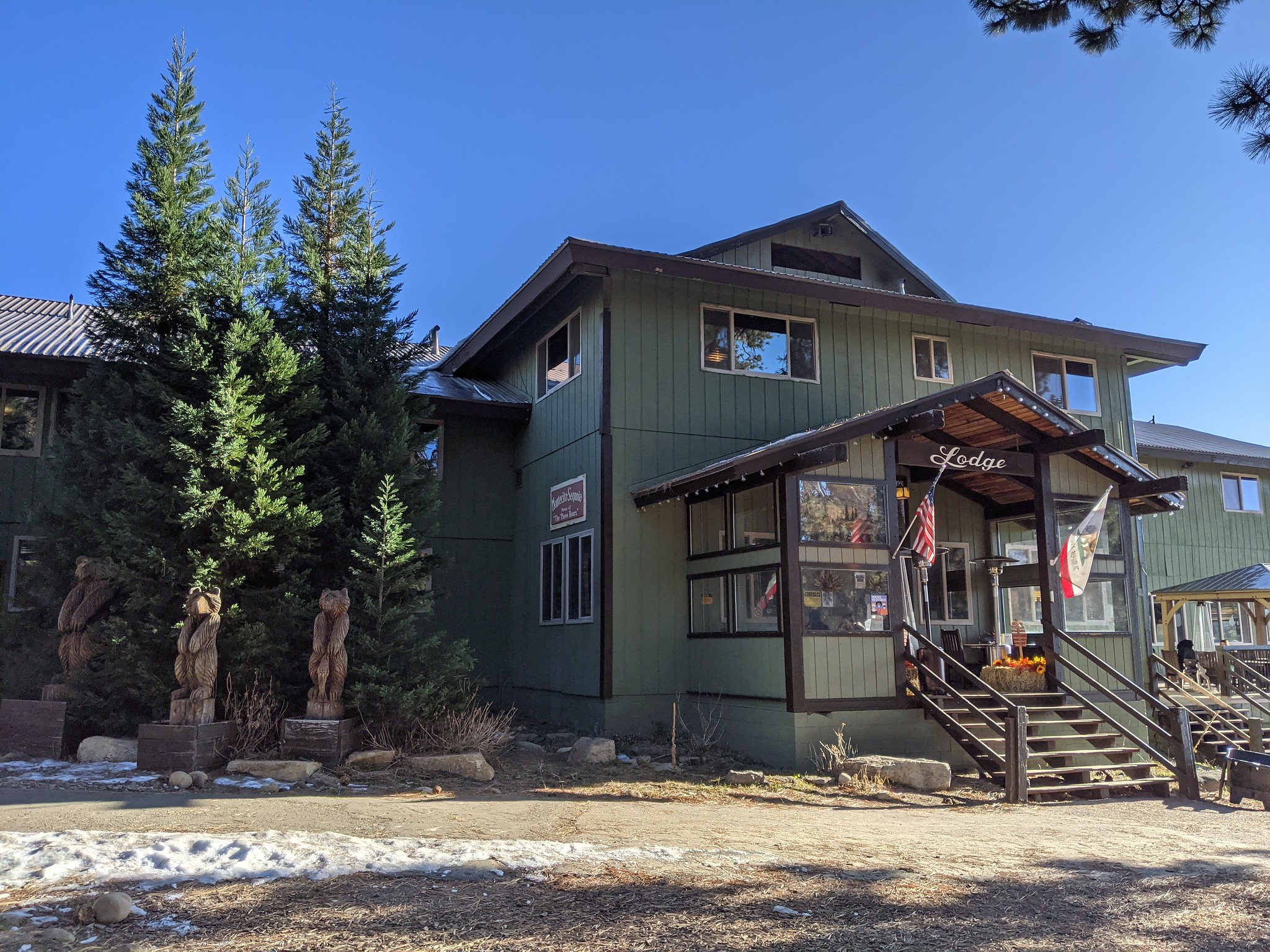 The simple wooden structure of Montecito Sequoia Lodge in Sequoia National Park, named as one of the best all-inclusive resorts in the U.S., with two flags by the entrance