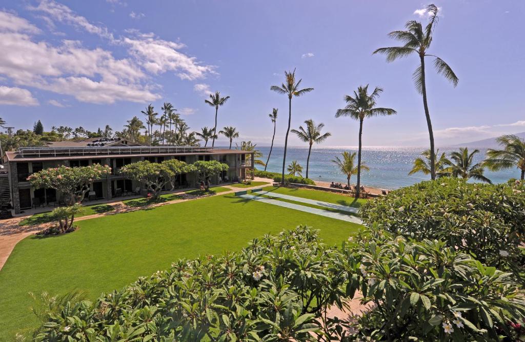 The Mauian Hotel overlooking the ocean with a gorgeous green terrace for a piece on the best hotels in Maui