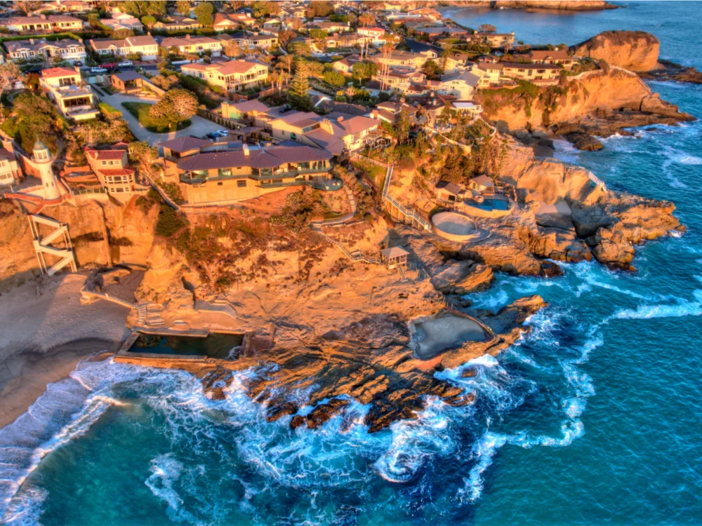 Waves crashing on the rocky coast at Three Arch Bay in Laguna Beach, California during sunset, considered as one of the best beaches in the US