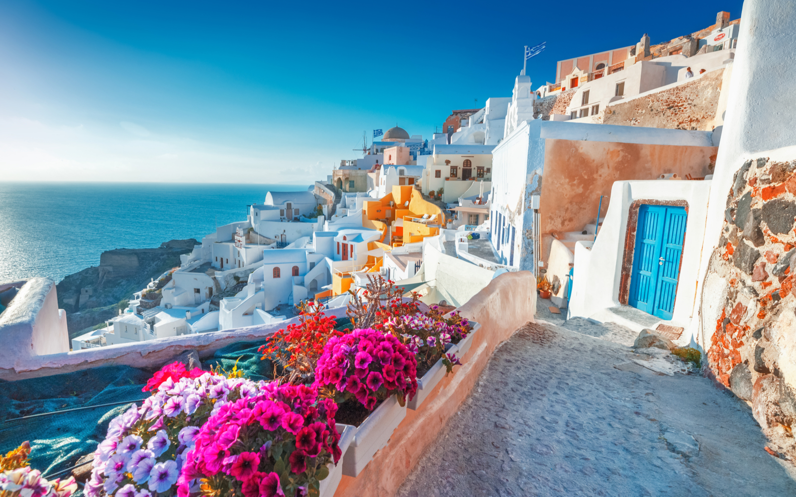 Shot of the cliffside town of Santorini on a clear summer day for a piece titled Is Greece Safe to Visit