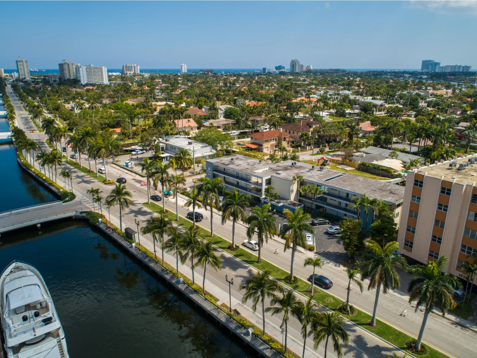 Aerial photo of Las Olas Boulevard with running cars during a clear day, boat docks and structures are on each side, a piece on the best things to do in Fort Lauderdale