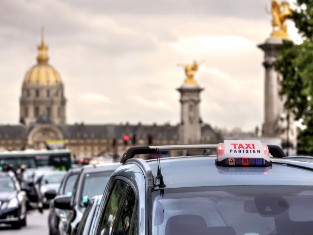 Parisian taxi with the Les Invalides in the background during the best time to visit Paris