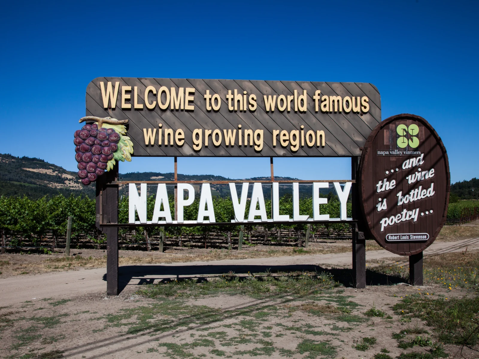 Sign that says Welcome to this world famous wine growing region Napa Valley in front of a deep blue sky