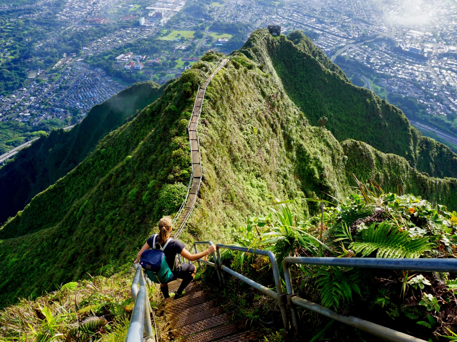 For a piece titled Is Hawaii Safe to Visit, a woman is pictured climbing the Stairway to Heaven hike on Oahu