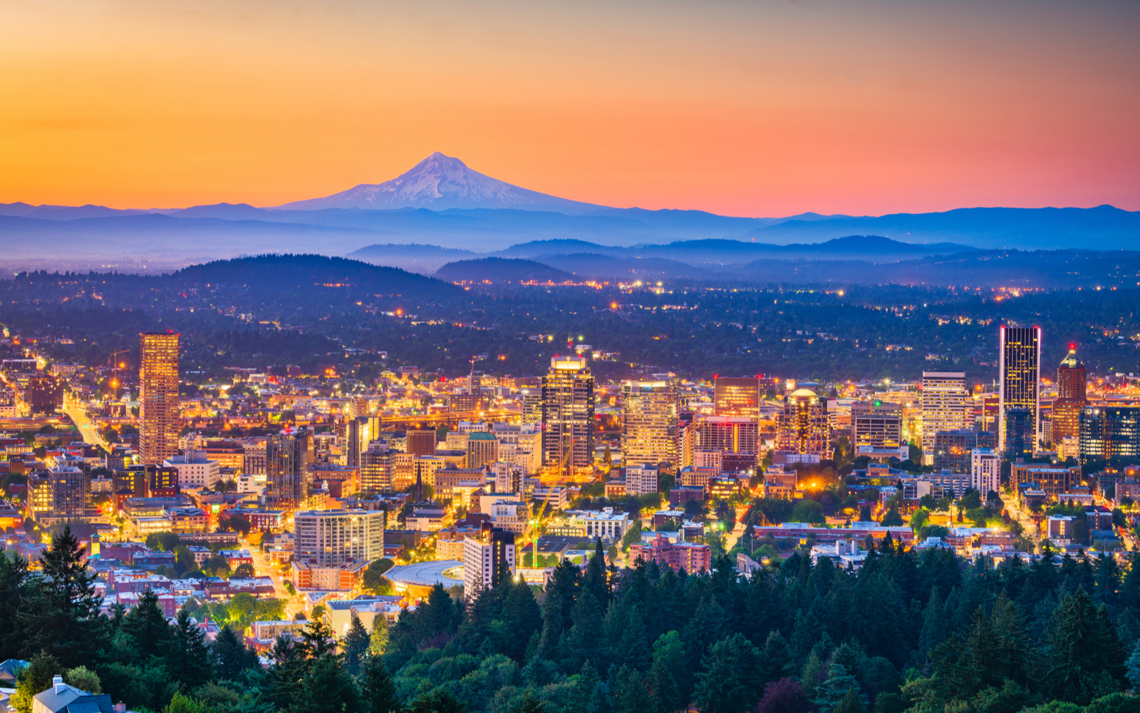 Skyline of Portland at dusk during the best time to visit Oregon with the city lighted up below