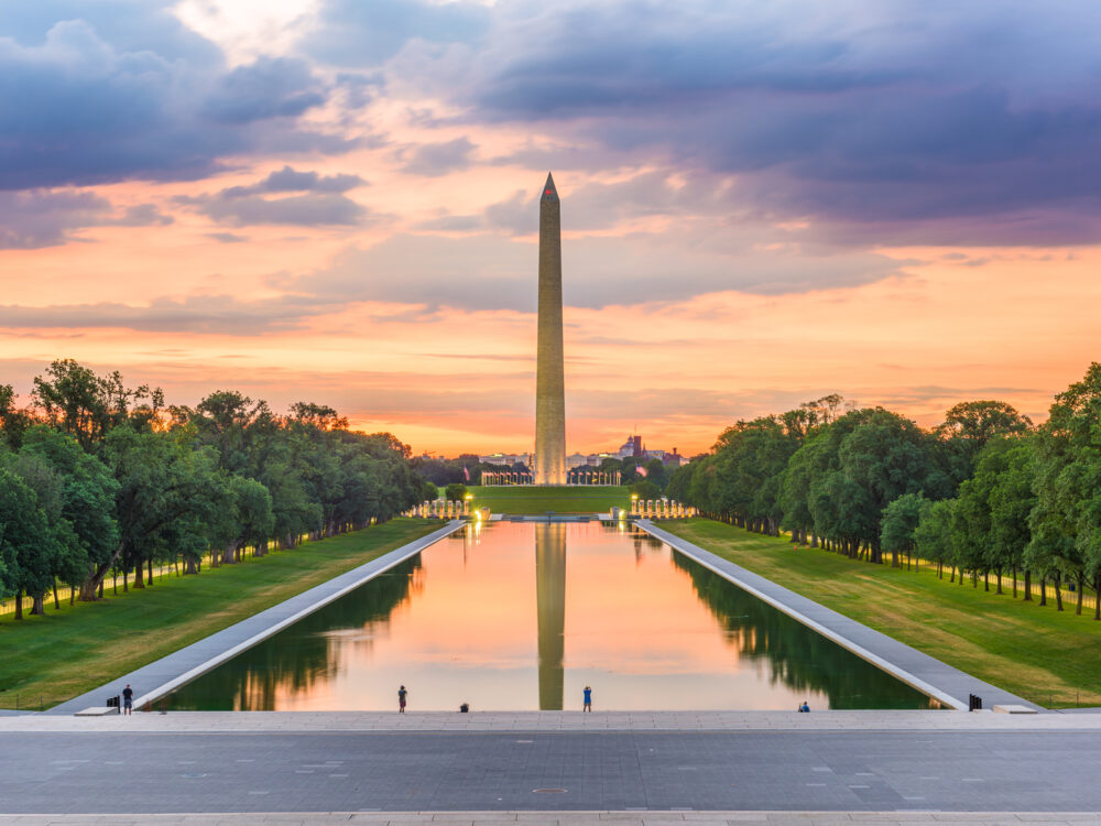 Beautifully captured photo of historic Washington Monument, one of the best things to do in Washington D.C., on the reflecting pool during a sweet sunset