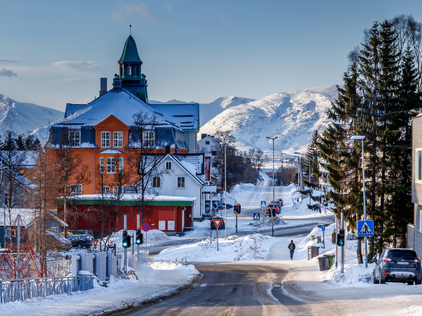 The city of Tromso pictured during the worst time to visit Norway with snow covering the streets and roofs
