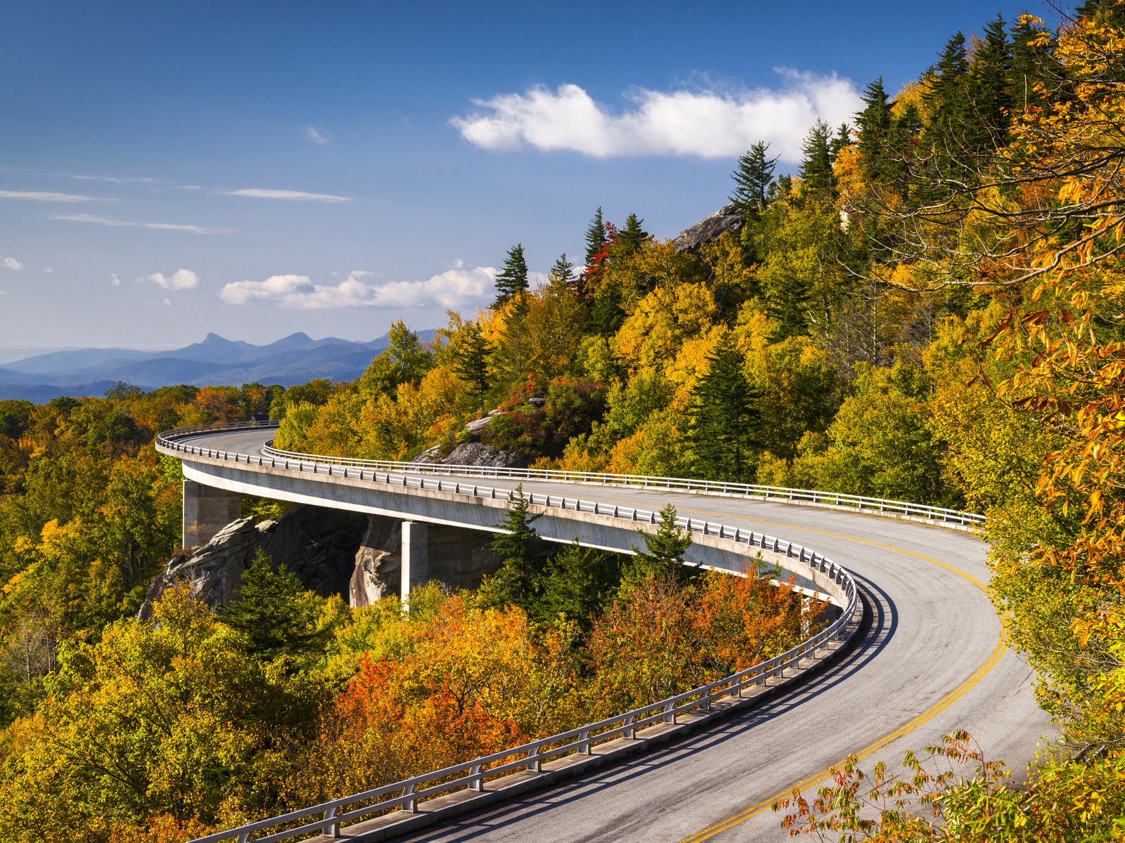 America's longest linear park is one of the best things to do in Asheville, NC with a curved road and a scenic view of Blue Ridge Mountains