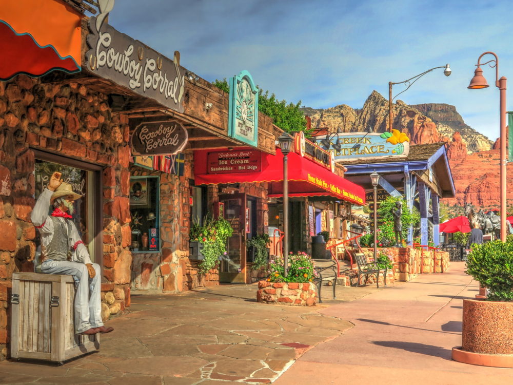 A marketplace with statues in front of some stores with traditional designs in downtown Sedona, Arizona, one of the most beautiful cities in the US