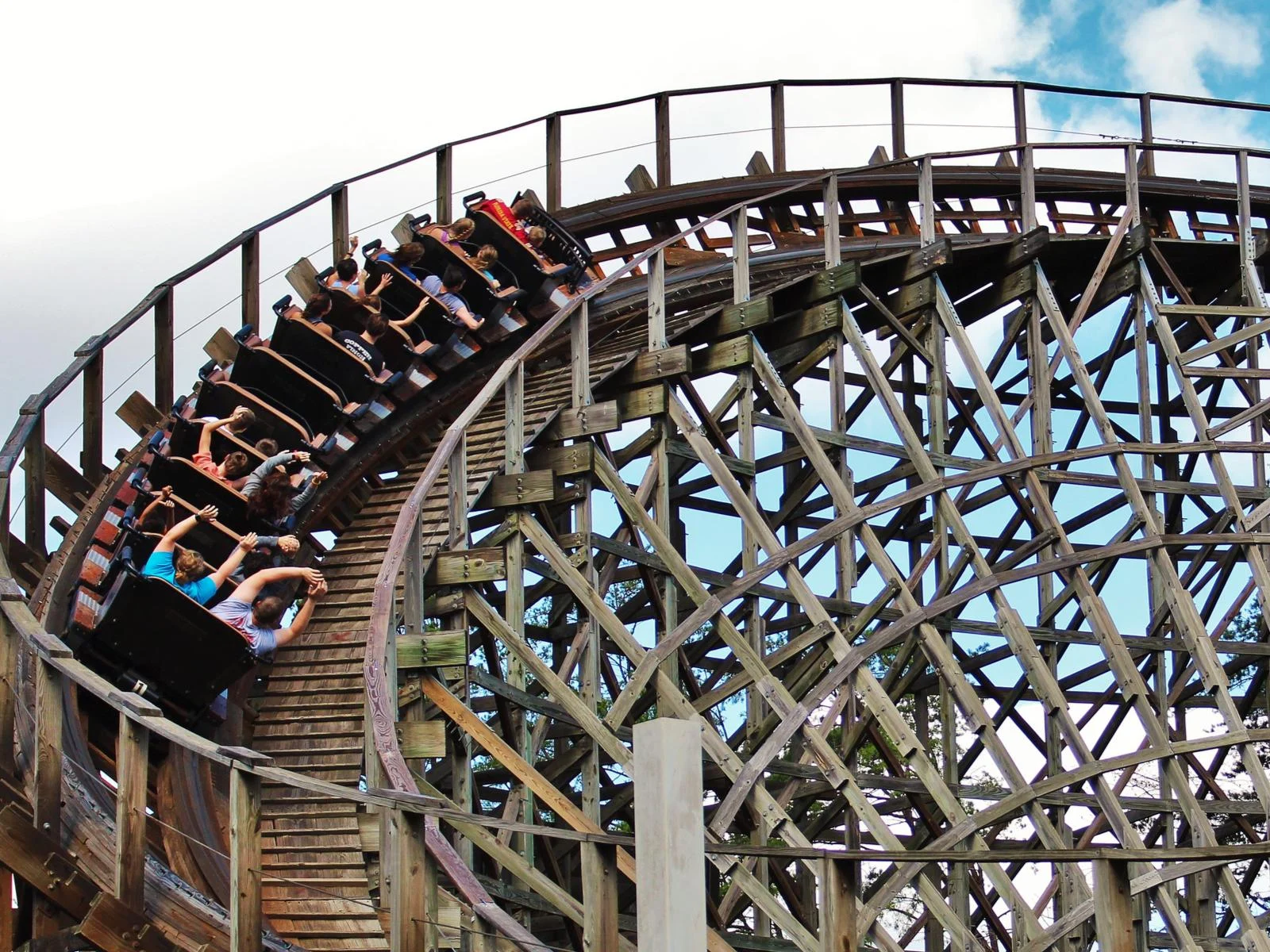 Visitors raise their hands as the wooden roller coaster in Dollywood in Pigeon Forge, Tennessee takes a swerve, a piece on the best roller coaster parks in the US