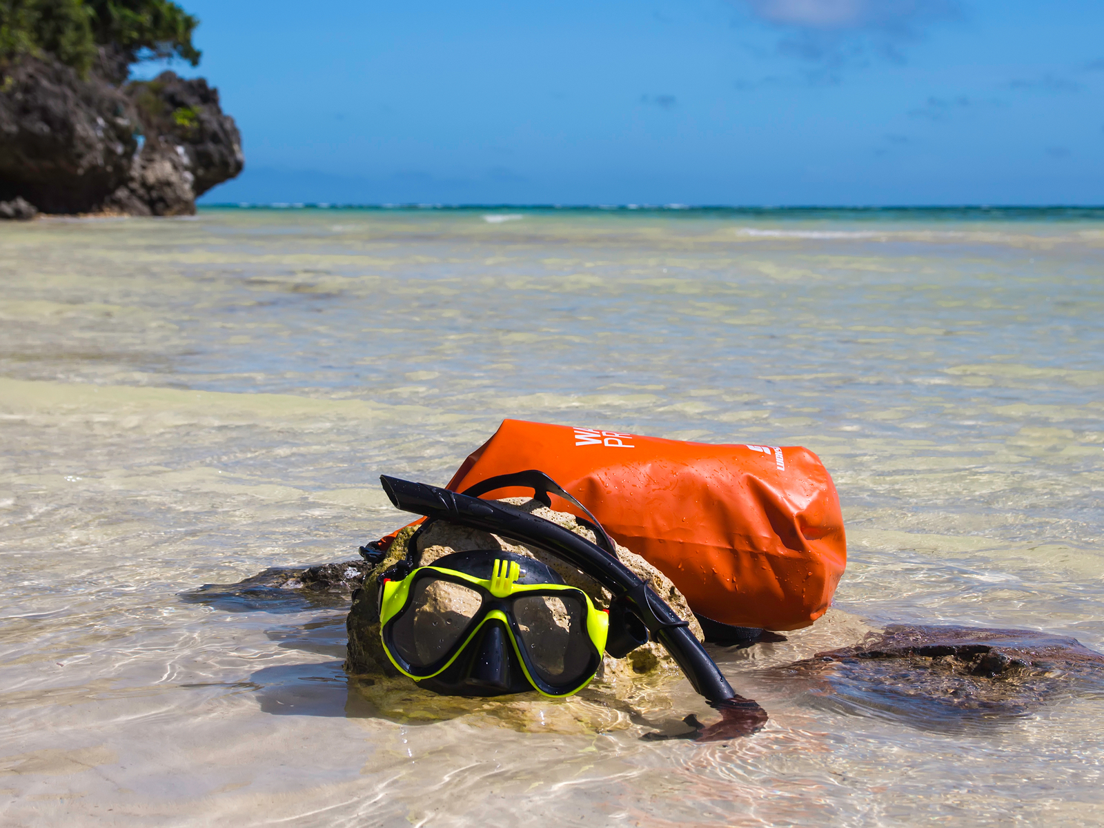 Snorkel mask on a rock in front of the best waterproof day bag