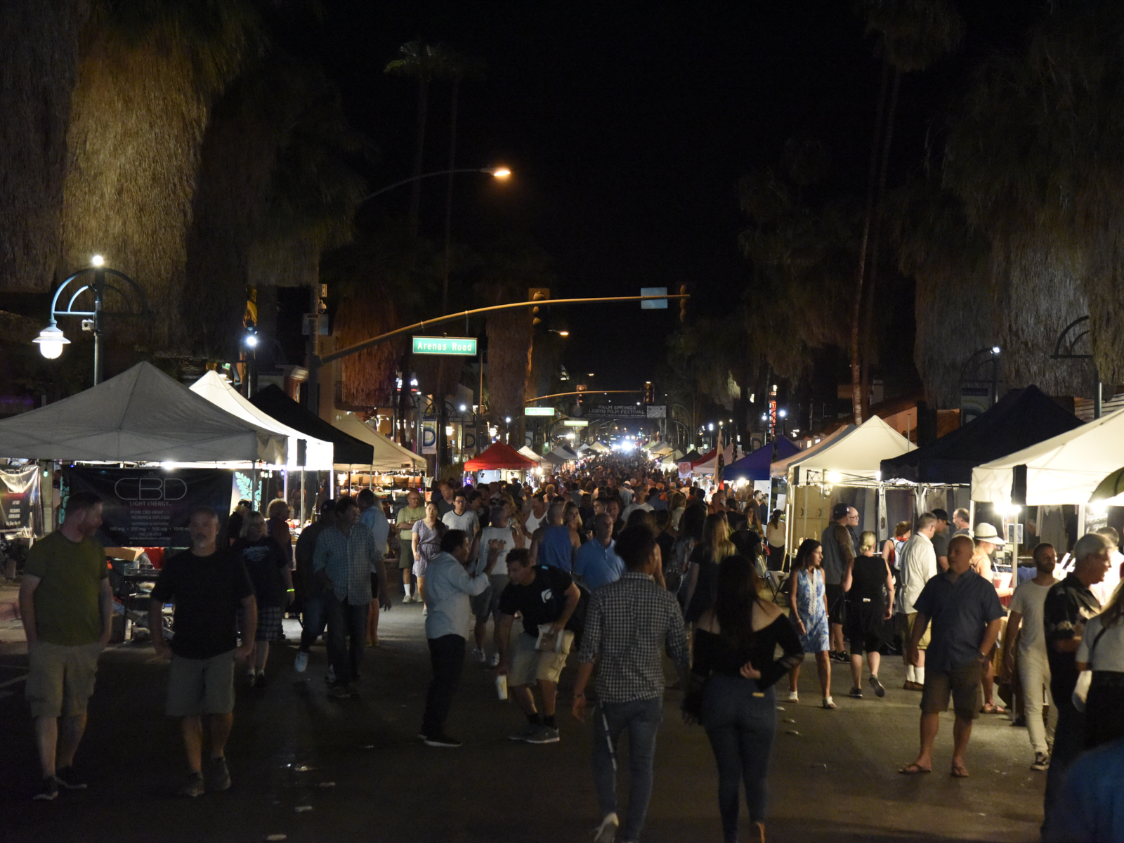 Busy night with a lot of people at lined up stalls in a Village Fest, one of the best things to do in Palm Springs