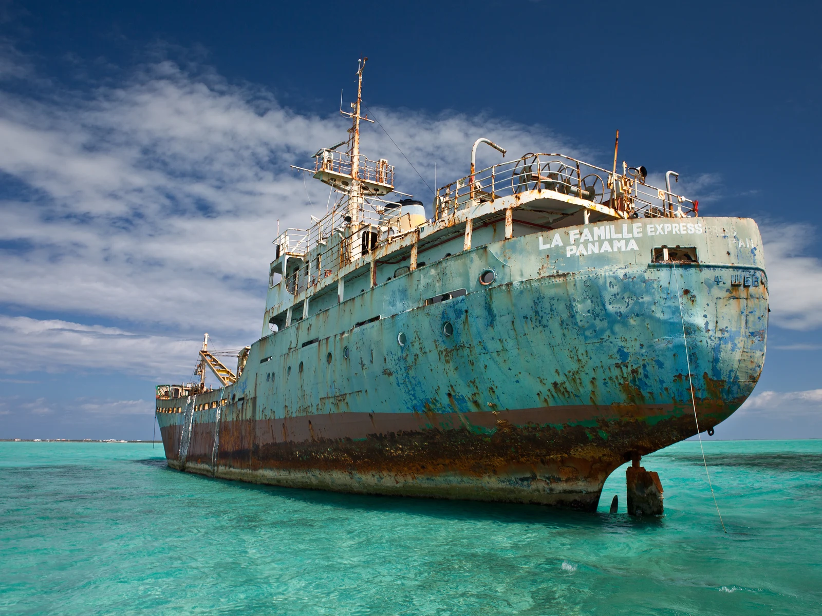 Old cargo ship run aground in the shallow teal water during the cheapest time to visit Turks and Caicos
