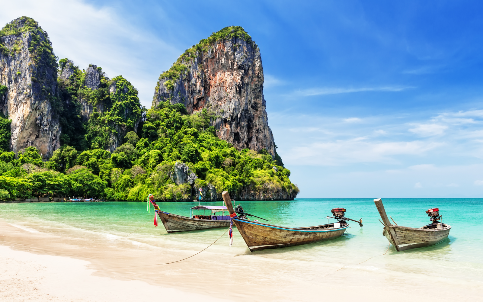 Traditional wooden longtail boat on Railay beach during the best time to visit Thailand
