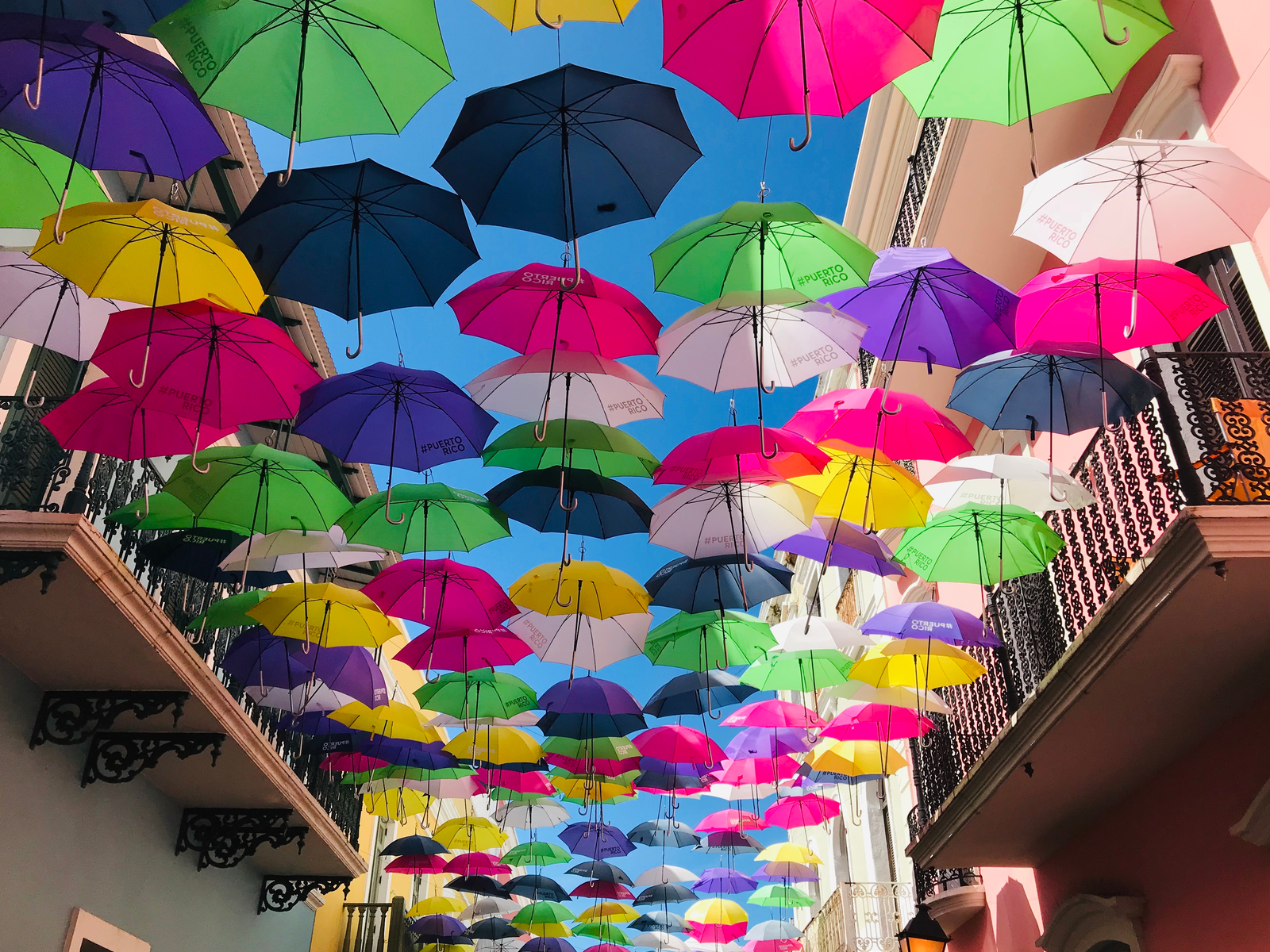 Vibrant umbrellas dangling above the street in Old San Juan, one of the best places to visit in Puerto Rico