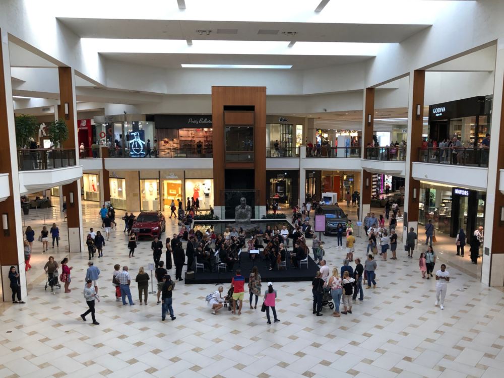 Several mall-goers stopped to watch a classical music event at the center stage of Aventura Mall in Florida, one of the best malls in America